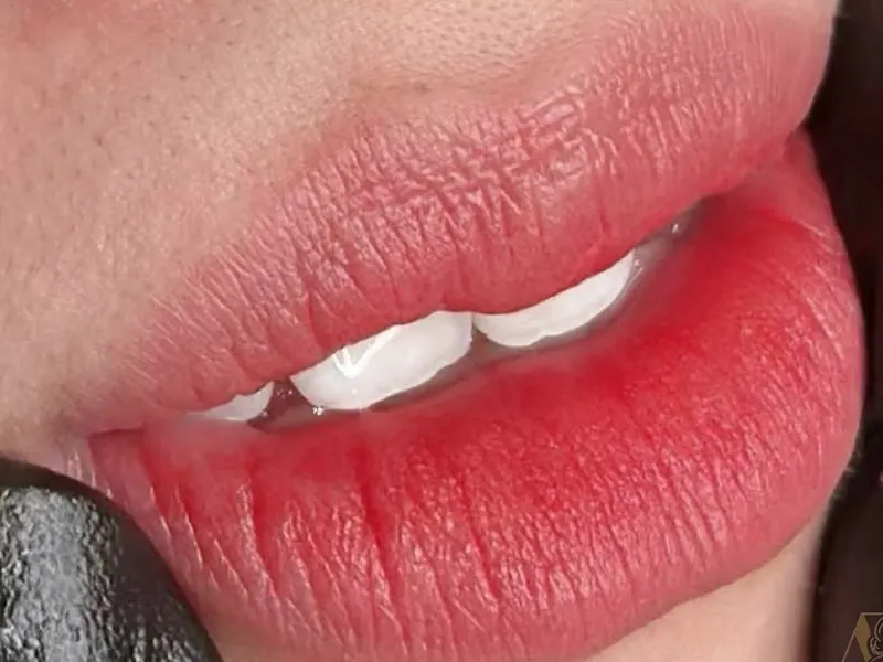 Close-up of lips in a strawberry shade after lip blush